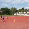 Tartanplatz mit Rasenplatz und Sporthalle im Hintergrund